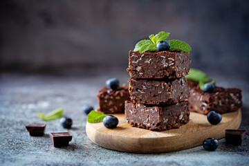 Dark chocolate oats millet porridge brownies decorated with blueberries and mint leaves