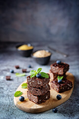 Dark chocolate oats millet porridge brownies decorated with blueberries and mint leaves