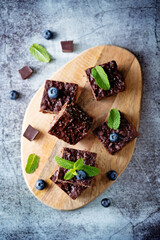 Dark chocolate oats millet porridge brownies decorated with blueberries and mint leaves
