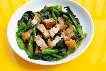Dish of Stir fried chinese kale with crispy pork belly