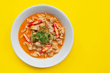Panaeng Curry with pork  in white bowl on yellow background.