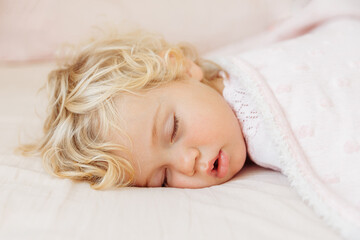 Obraz na płótnie Canvas Baby girl sleeping under pink blanket.