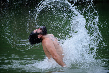 Carefree and positive thinking. Man splashing water by hair. Summer weekend.