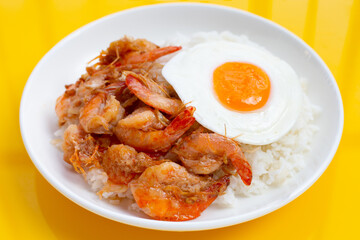 Spicy stir fried prawns with fried egg on rice
