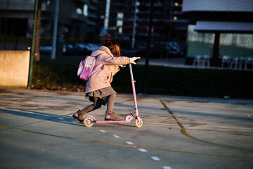 girl with scooter doing tricks