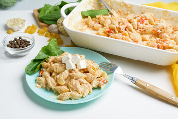 trend oven-baked feta cheese with tomatoes and pasta, pepper garlic on a light background top view, mixing macaroni and cheese