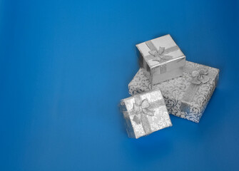 3 silver jewelry boxes on the blue background. gift boxes with copy space