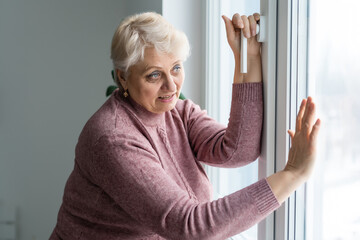 Woman opening the window to take a breath. Quarantine concept