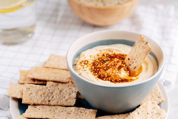 Hummus and Baba ghanoush in a bowl with crispbread on a light table. Mediterranean appetizer, vegetarian healthy food concept. Top view, flat lay, copy space.
