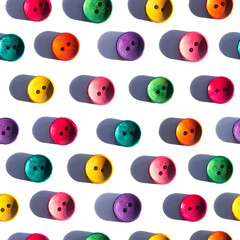 A seamless pattern photo collage in pop-art style. Variety of bright colorful orange yellow red blue green wooden buttons isolated on white background