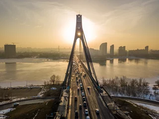 Foto op Canvas North bridge in Kiev at sunset. Aerial drone view. Spring evening, the sun's rays pass through the pillars of the bridge. © Sergey