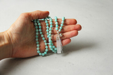 Rosary mala 108 beads from natural stones mint amazonite lie in girl's hand. Author's jewelry from natural stones, Buddhism, matra, prayer, rosary from stones for prayer and beauty. Rosary in hand