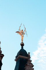Fototapeta na wymiar Escultura de un ángel dorado sosteniendo rayos en sus manos (Bélgica)