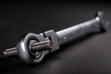 A screw and a metal wrench in the workshop. Accessories for mounting metal elements. Dark background. 