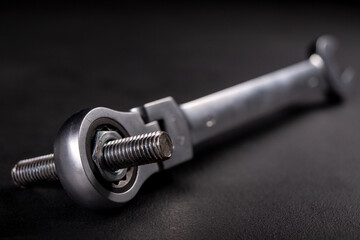 Fototapeta premium A screw and a metal wrench in the workshop. Accessories for mounting metal elements. Dark background. 