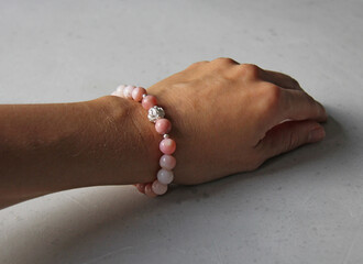 Pink opal bracelet. A bracelet made of stones on a hand from natural stone Pink opal. Bracelet made of natural stones. Handmade jewelry. Handmade bracelets on light modern background