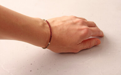 Ruby bracelet. Bracelet made of stones on hand from natural stone Ruby. Bracelet made of natural stones. Handmade jewelry. Handmade bracelets on light modern background