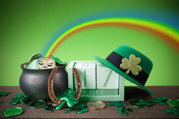 Happy St. Patrick's day. Shiny shamrocks, gold coins and leprechaun hat on a wooden background with...
