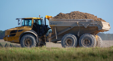 Obraz premium articulated Volvo A40E dump truck earth mover fully laden with 25 tonne load driving across Salisbury Plain, Wiltshire UK