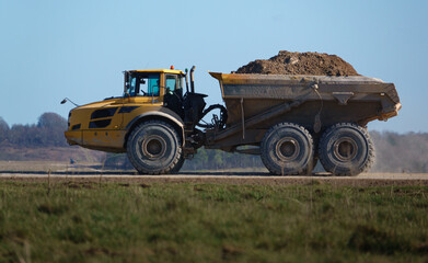 Obraz premium articulated Volvo A40E dump truck earth mover fully laden with 25 tonne load driving across Salisbury Plain, Wiltshire UK