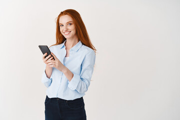 Social networking concept. Young woman with long red hair and white smile looking happy at camera,...