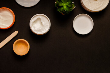 White colored blank cosmetic container for face cream moisturizer isolated on black background. Cosmetics. Face and body skin care.top view.