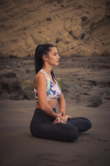 Fototapeta na wymiar a young woman relaxes and does yoga on the beach exercise, free time and healthy life