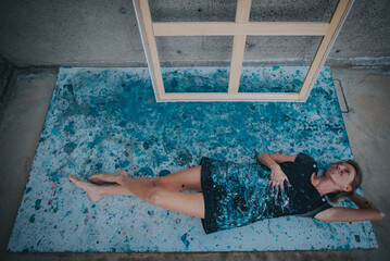 you can see a young female painter resting on a paper covered by paint