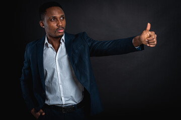 handsome handsome african american man in suit showing ok sign, on dark background. Cool man making ok symbol. Business success concept