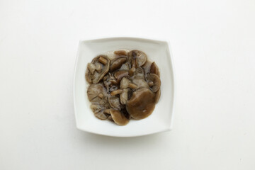 Pickled mushrooms mushrooms in a white plate isolated on white background