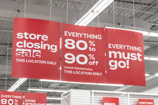 Store Closing and huge discount signs displayed at a soon to be out of business clearance sale. Everything must go at up to 90 percent off sale.
