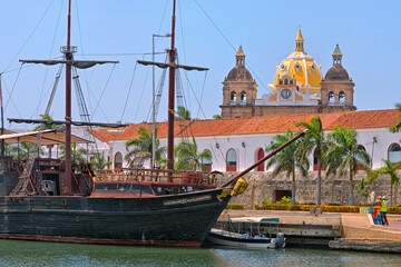 Old styled sail boat in the harbor and Iglesia de San Pedro Claver in the old town, Cartagena,...