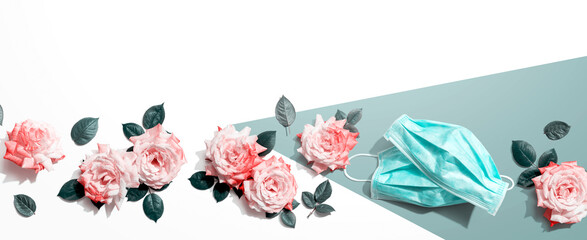 Face masks with pink roses overhead view - flat lay