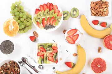 Healthy breakfast with ingredients, fruit salad with strawberries, muesli, grapes, banana and chia seeds for weight loss. The concept of natural nutrition and detox diet, lifestyle, selective focus,