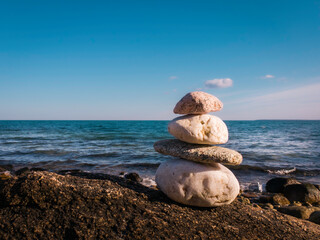 Zen marble rocks, tranquil seascape background on blue sky in the back