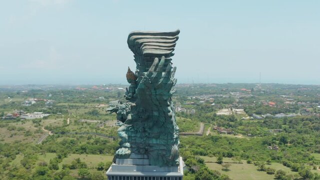 Side view of huge copper statue in Bali, Indonesia. Garuda Wisnu Kencana statue rising above the city
