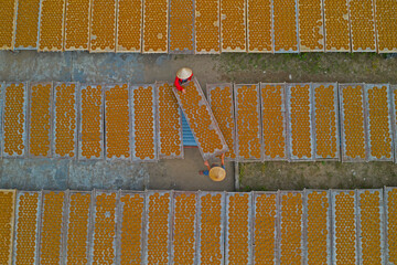 Aerial view of two people working in a farm with round incense, preparing the incense on similar trays, Hung Yen, Vietnam.