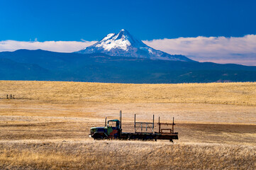 Naklejka premium A farm truch in a dry pasture on a farm near Dufur Oregon, with Mt Hood in the background.