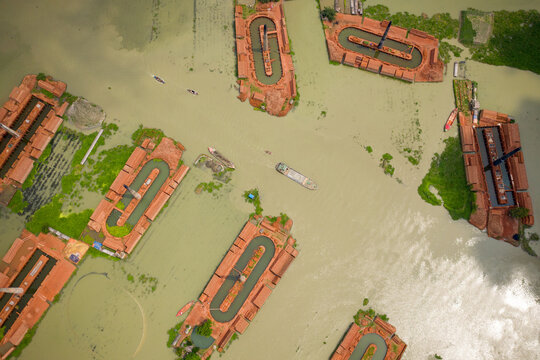 Aerial view of chimneys from local brick factories flooded by monsoon rains near Savar, Dhaka, Bangladesh.
