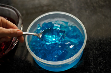 Homemade gelatin, cut into cubes. Excellent dessert, typical Brazilian. The focus of the photo is on the gelatin in the spoon.