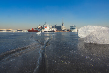 Obraz premium Massive different ship vessels trapped in ice tries to break and leave the bay between the glaciers, icebreaker and carrier vessel, winter blue sky view