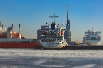 Massive different ship vessels trapped in ice tries to break and leave the bay between the glaciers, icebreaker and carrier vessel, winter blue sky view