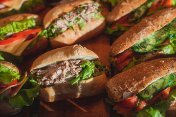 Beautifully decorated catering banquet table with different food snacks and appetizers with sandwich on a wooden plate, on corporate christmas birthday kids party event or wedding celebration