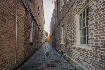 Fototapeta na wymiar Lodge Alley in Charleston, South Carolina is one of city's few remaining cobblestone streets. Charleston is famous for it's hidden and secret alleyways and this one dates back to the early 1700s.