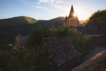 Golden sunrise or sunset light over the quaint and charming medieval French village of Conques,...