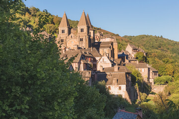 The quaint and charming medieval French village of Conques, Aveyron, and Abbey Church of Sainte-Foy, a popular summer tourist destination in the Occitanie region of France.