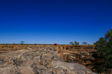 Fototapeta na wymiar Bladensburg National Park with red 4wd car in distance. Large amount of clear blue sky with horizon.