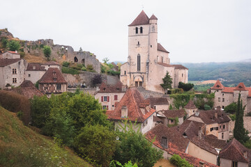 Fototapeta premium The French medieval hilltop village of Saint-Cirq-Lapopie and its 16th century fortified church in the Lot Valley, France.