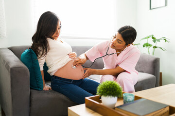 Professional nurse examining the belly of an expectant mother
