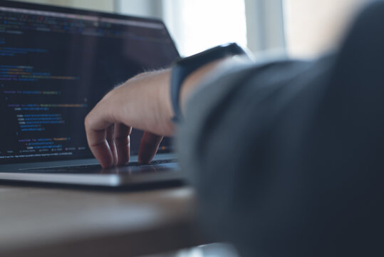 Software engineer, application developer coding javascript on laptop computer, close up, software development concept